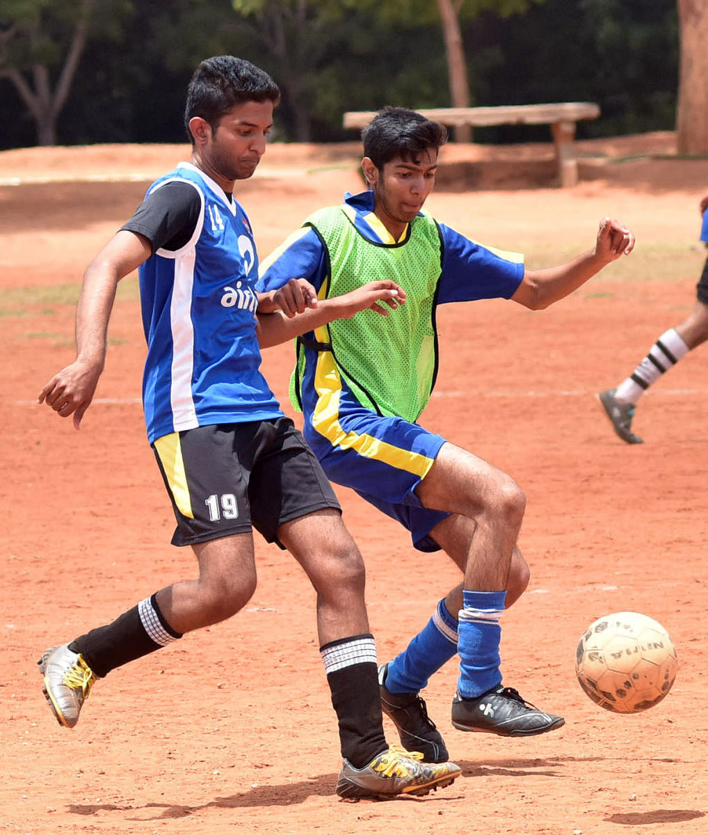 St. Joseph College (Blue) and NIE College (Green) vie for the ball during the Chief Justice Hombegowda Memorial Mysuru University inter College Gold Cup Football Tournament organised by Mysuru Physical Education Department at University Pavilion in Mysuru on Monday.-Photo by Savitha. B R