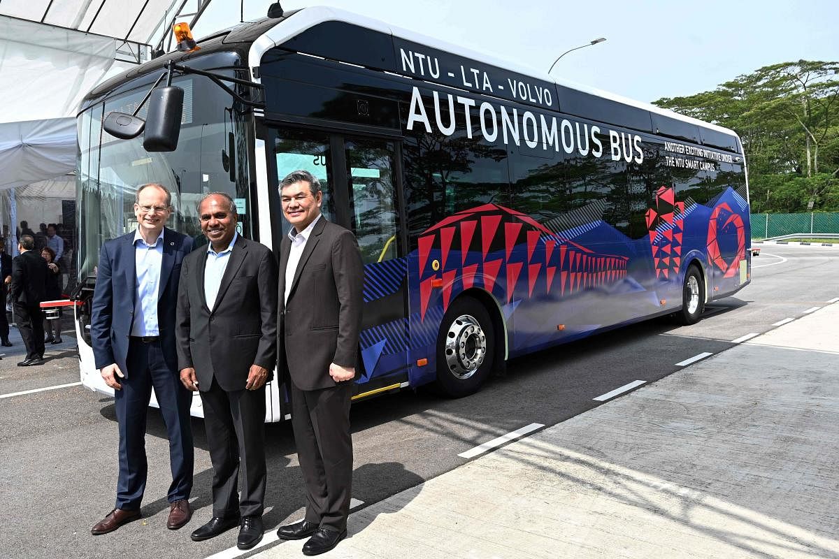 Nanyang Technology University President Subra Suresh (C), Volvo Buses President Hakan Agnevall (L) and Land Transport Authority Chief Innovation and Technology Officer, Lam Wee Shann (R) pose after unveiling Volvo's first full size autonomous electric bus in Singapore on March 5, 2019. (Photo by ROSLAN RAHMAN / AFP)