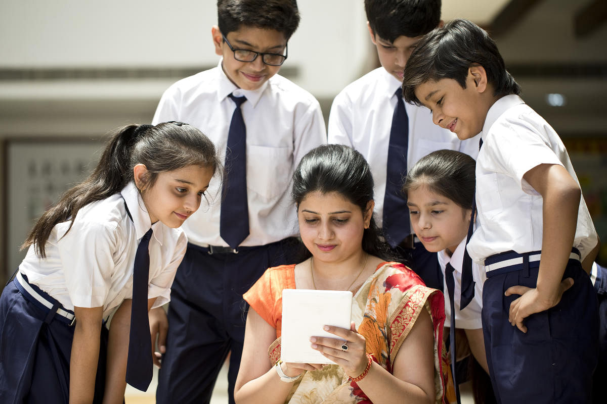 Teacher explaining to students using digital tablet