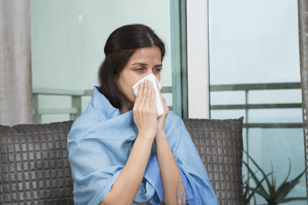 Sick woman blowing her nose - Stock image