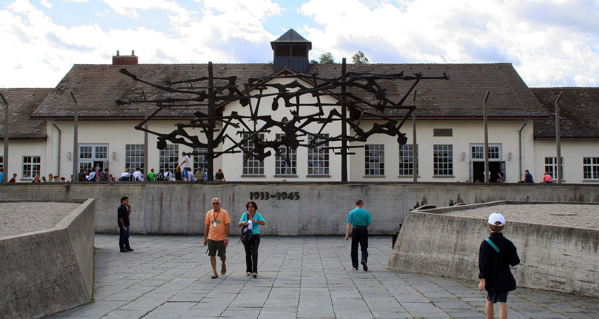 Dachau, Germany - July 24, 2007: Visitors walk outside the main building at Dachau concentration camp (Konzentrationslager (KZ) Dachau) and take in the International Memorial in front of it.Images