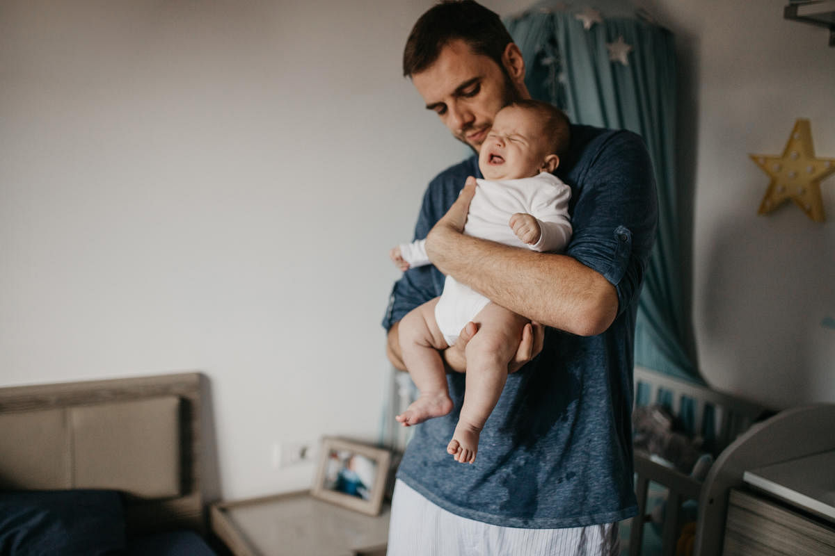 Father holding crying colicky baby