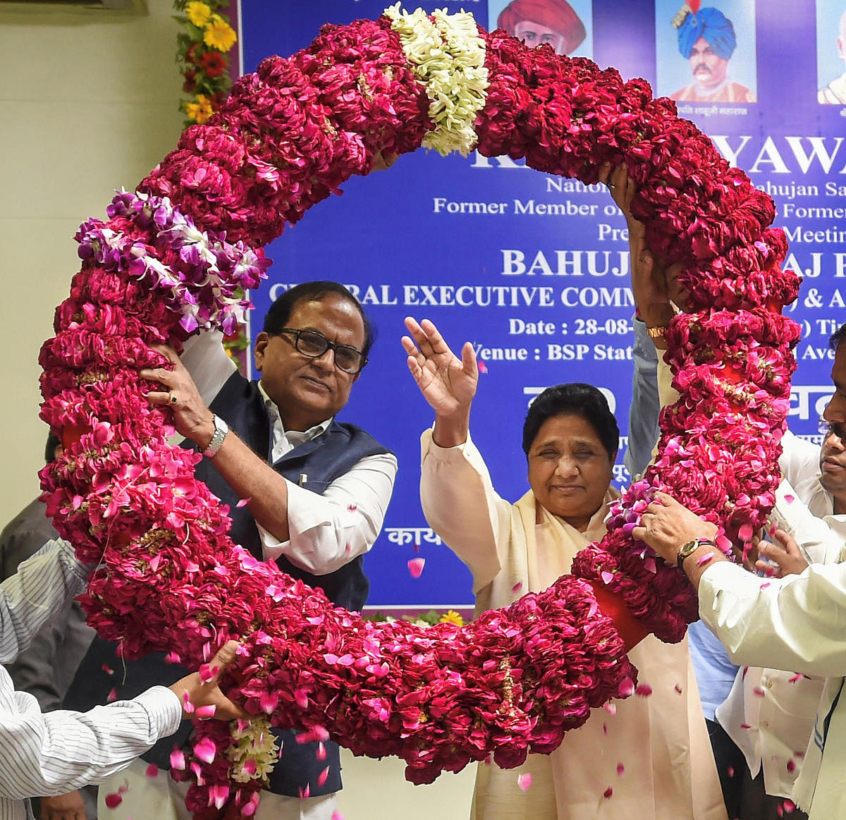 Lucknow: Bahujan Samaj Party (BSP) supremo Mayawati waves as she is garlanded by the party workers after being re-elected as the party president during a meeting, at BSP headquarters in Lucknow, Wednesday, Aug 28, 2019. BSP MP Satish Chandra Mishra is also seen. (PTI Photo/ Nand Kumar) (PTI8_28_2019_000039A)