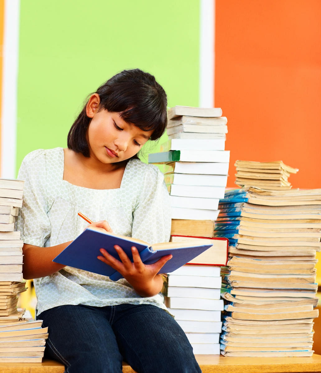 Girl with stack of books reading