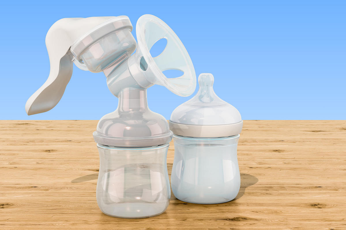 Manual breast pump on the wooden table, 3D renderingManual breast pump on the wooden table, 3D rendering