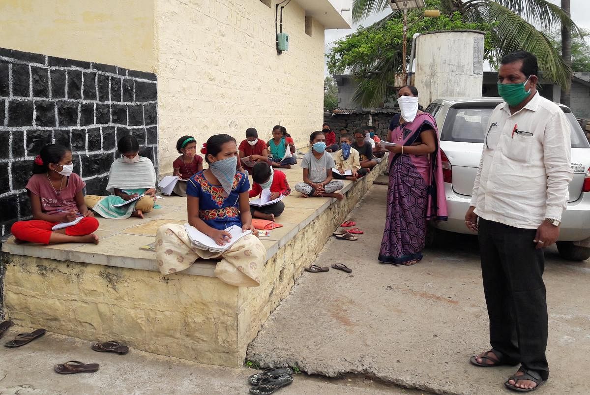 ಕಮಲಾಪುರ ತಾಲ್ಲೂಕಿನ ಓಕಳಿ ಗ್ರಾಮದ ವಠಾರದಲ್ಲಿ ಮಕ್ಕಳಿಗೆ ಪಾಠ ಮಾಡುತ್ತಿರುವ ಶಿಕ್ಷಕರು