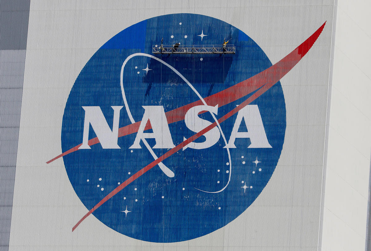 FILE PHOTO: Workers pressure wash the logo of NASA on the Vehicle Assembly Building at the Kennedy Space Center in Cape Canaveral, Florida, U.S., May 19, 2020. REUTERS/Joe Skipper/File Photo