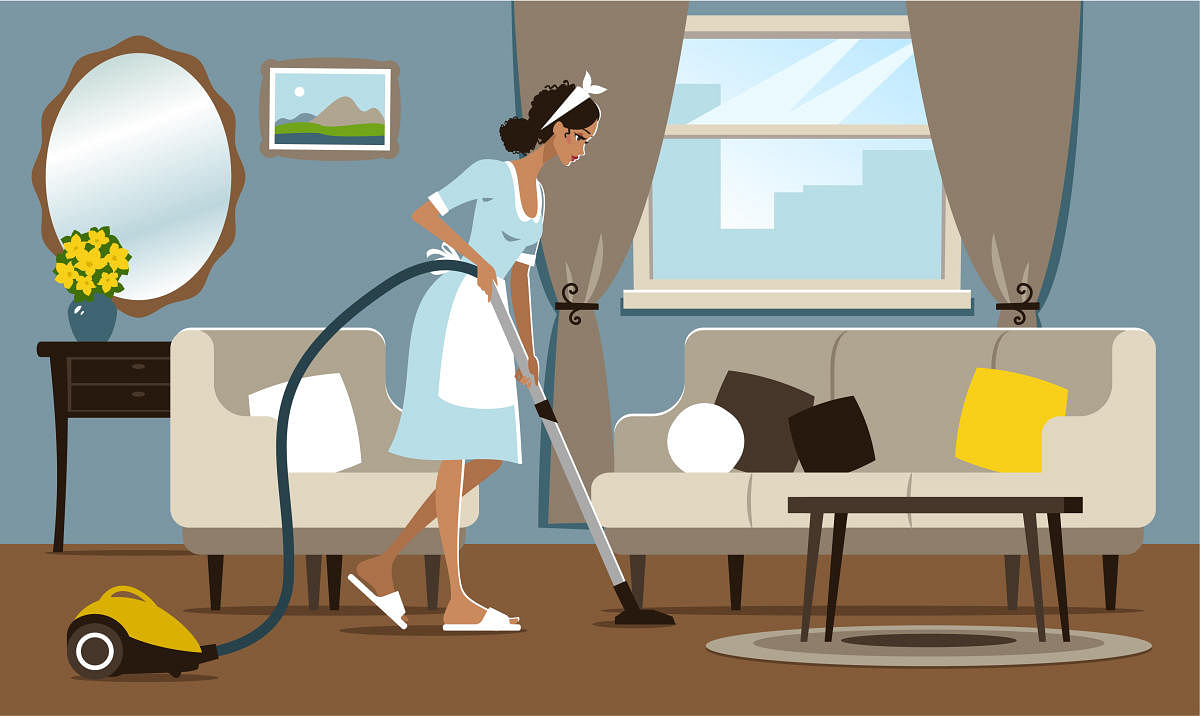 Young woman vacuuming a hotel room.Young woman vacuuming
