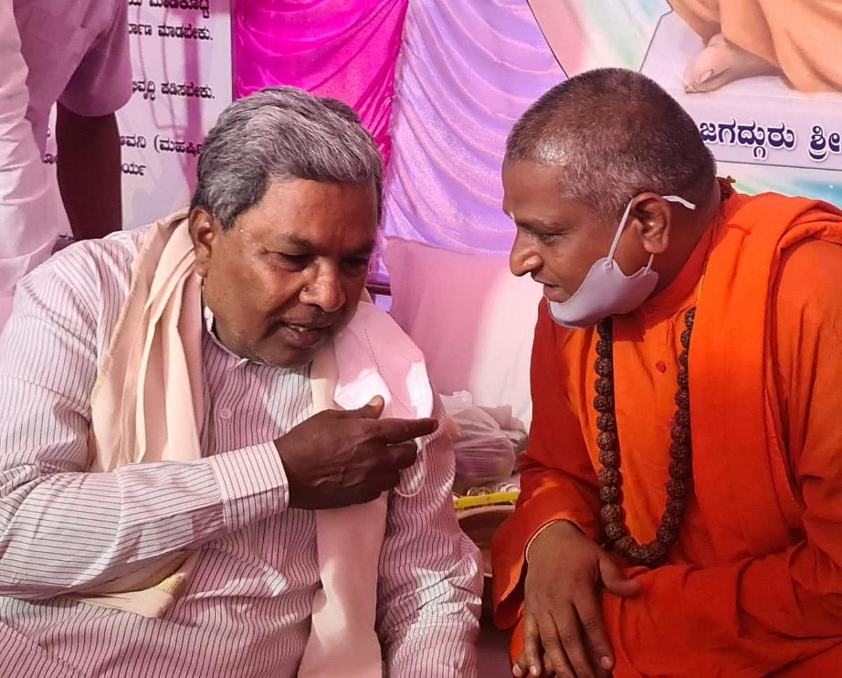 ವಿಧಾನಸಭೆ ವಿರೋಧ ಪಕ್ಷದ ನಾಯಕ ಸಿದ್ದರಾಮಯ್ಯ ಅವರು ವಾಲ್ಮೀಕಿ ಗುರುಪೀಠದ ಪ್ರಸನ್ನಾನಂದ ಸ್ವಾಮೀಜಿ ಅವರೊಂದಿಗೆ ಚರ್ಚಿಸುತ್ತಿರುವುದು