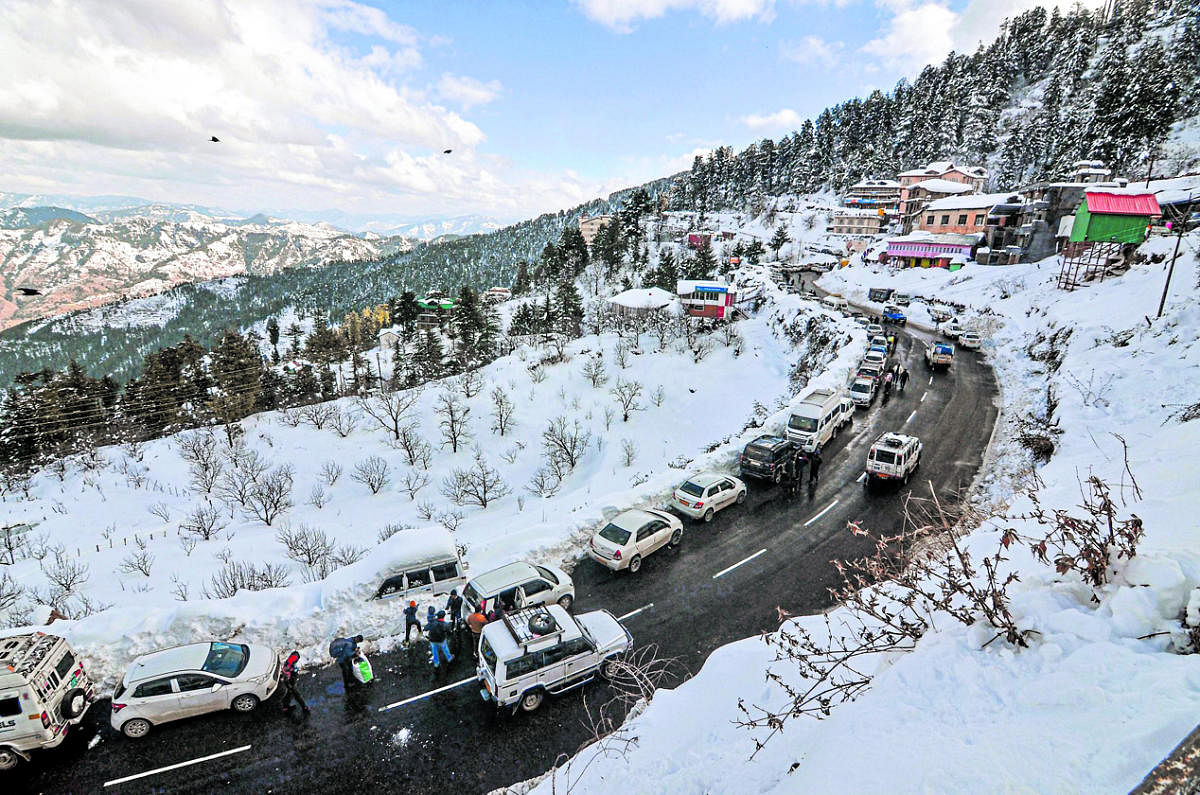 Shimla: Vehicles ply on a road after heavy snowfall at Kufri near Shimla, Tuesday, Jan. 11, 2022. (PTI Photo)(PTI01_11_2022_000121A)